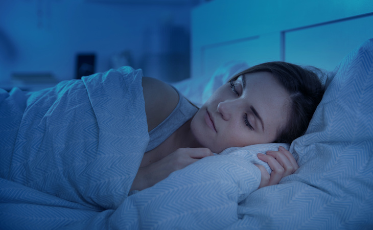 person sleeping in dark bedroom