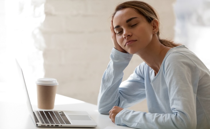 tired person falling asleep at desk, experiencing a microsleep