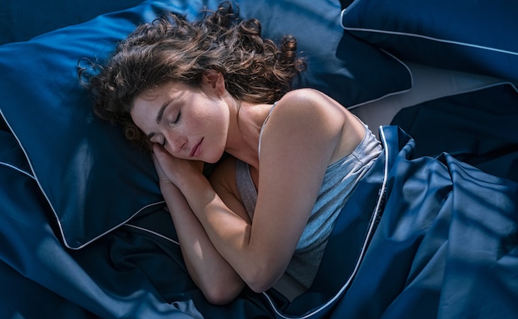 person practicing sleep syncing asleep in bed