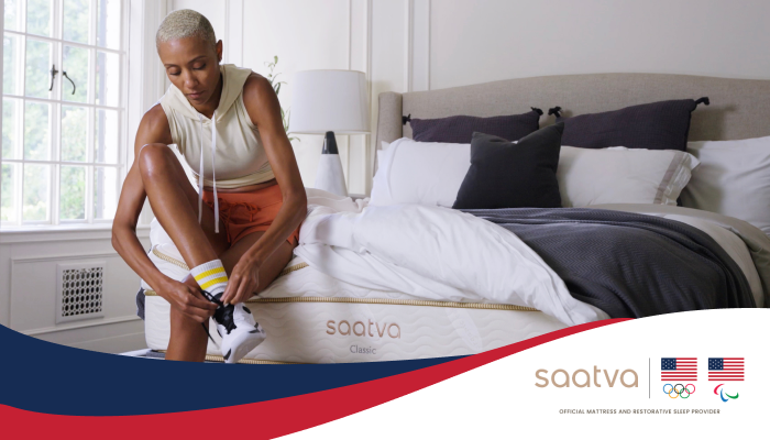 person tying sneaker while sitting on bed