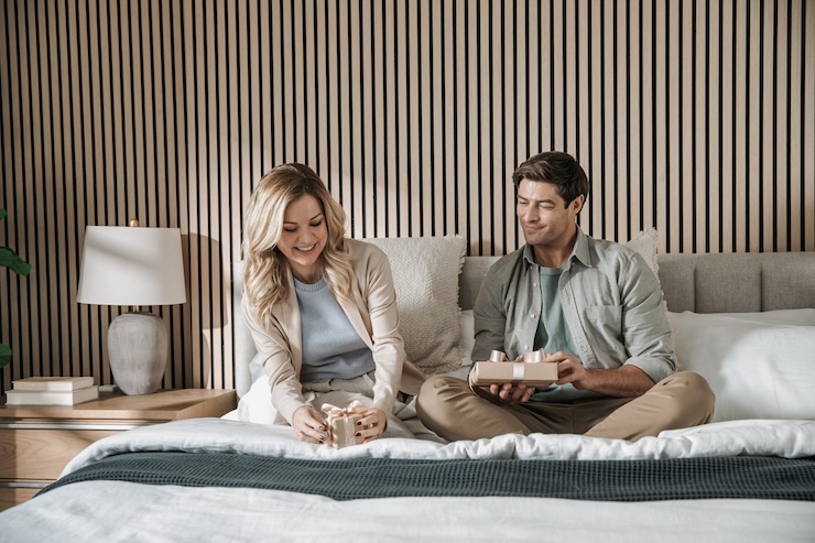 couple opening sleep gifts in bed